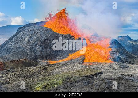 Eruption of an active volcano on the Reykjanes Peninsula. strong lava flow from a volcanic crater in Iceland. liquid magma from crater at day in sunsh Stock Photo