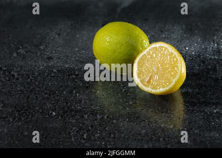Fresh ripe lemons on a dark stone background. With copy space. Stock Photo