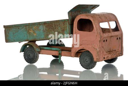 Old rusty toy on a white background. Child dump truck. Stock Photo