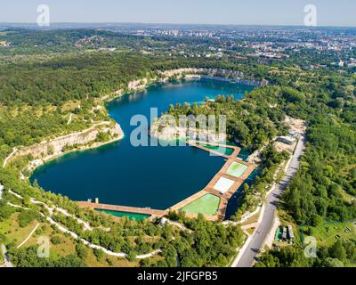 Krakow, Poland. Zakrzowek lake with steep cliffs in place of former flooded limestone quarry. Recreational place with swimming pools, restaurants and Stock Photo