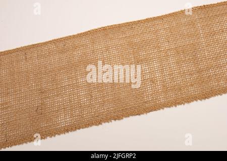 A closeup of a hessian jute cloth laid diagonal isolated on white background Stock Photo