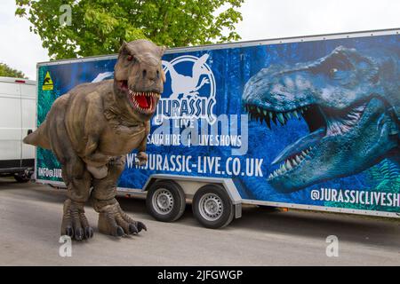 Dino Jurassic Live in Southport, Merseyside.  UK Entertainment, Jurassic Live- Meet the scarily realistic T-Rex Dinosaurs show event roarsome adventure in Victoria Park Far Away Land family festival.  Jurassic World Live is a live show produced by Feld Entertainment and NBC Universal based on the Jurassic World franchise.  Families with children flocked to Victoria Park for a 'Far Away Land' to see animatronic giant walking dinosaurs a pre-historic weekend experience. Stock Photo