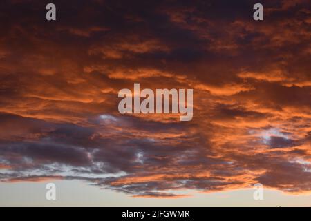 Black and orange dramatic skies as Nimbostratus clouds gather at sunset just before a Summer rain storm Stock Photo
