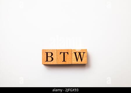 BTW characters. by the way. Written on three wooden blocks. Black letters. White background. Stock Photo