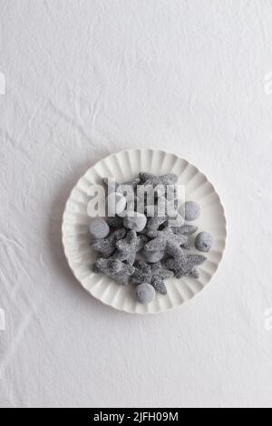 Salty liquorice salmiakki in Finnish in a white plate top view Stock Photo