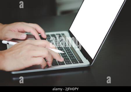 businessman using and typing on laptop with blank white screen mock up. Stock Photo