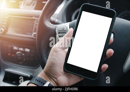 male hand holding a mobile phone in the car cabin.Blank with white screen.Mock up smart phone interior car. Stock Photo