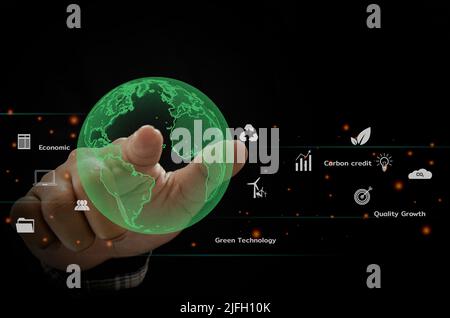 Green Globe hand carbon emissions and environmental protection, the future uses the technology of resources to reduce pollution.ESG business concept. Stock Photo