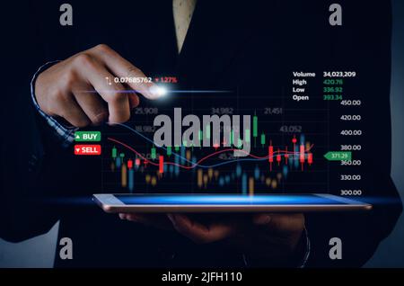 Stock market chart business using a tablet to analyze online trading data.Forex graph financial and investment on a virtual screen concept. Stock Photo