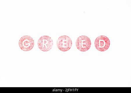 Red color rubber stamp in word greed on white paper background Stock Photo