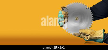 Carpenter with protective work gloves holding a metal circular saw blade, on orange and yellow background with copy space and reflections. Stock Photo