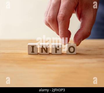 Info concept. Word info on wooden cube with finger to touches letter o. Information, advised message for assistance, support, solution, ask and answer Stock Photo