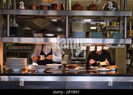 View of two chefs that prepare dishes in a restaurant Stock Photo