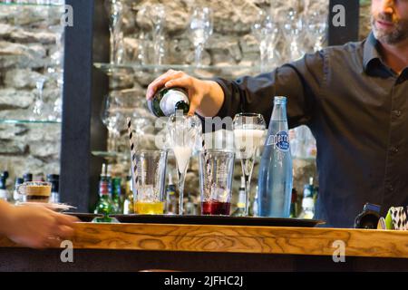 Barman serving a drink in a french pub Stock Photo