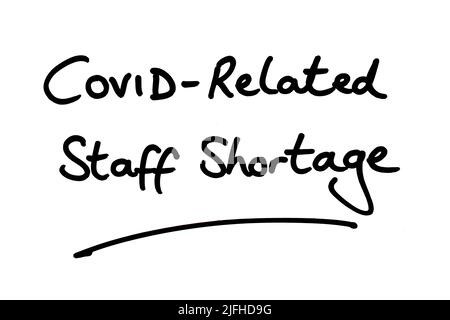 COVID-Related Staff Shortage, handwritten on a white background. Stock Photo