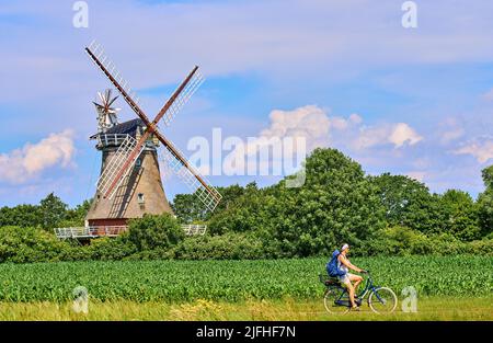 Tourist woman passing the Windmill in Oldsum  on June 29, 2022  in Wyk, Foehr Island, Germany.  © Peter Schatz / Alamy Stock Photos Stock Photo