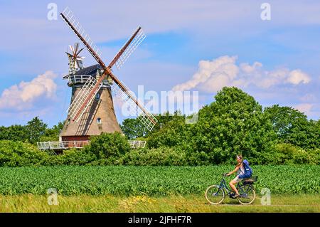 Tourist woman passing the Windmill in Oldsum  on June 29, 2022  in Wyk, Foehr Island, Germany.  © Peter Schatz / Alamy Stock Photos Stock Photo