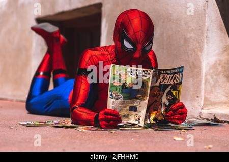 Closeup of person in the Spider-Man costume looking through a magazine in downtown Fort Worth on sunny day Stock Photo