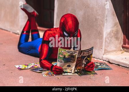 A closeup of a person in the Spider-Man costume looking through a magazine. Fort Worth, Texas. Stock Photo