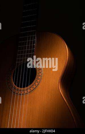 Spanish classical guitar close up, dramatically lit on a black background with copy space. Stock Photo