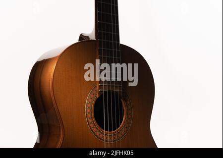 Spanish classical guitar close up, dramatically lit on a white background with copy space. Stock Photo