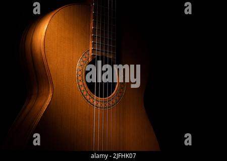 Spanish classical guitar close up, dramatically lit on a black background with copy space. Stock Photo