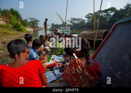 Gypsy children attend at class at a floating school on a canal at Sahapur in Sonargaon, Narayanganj, Bangladesh. Stock Photo