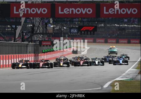 Silverstone, UK. 3rd July 2022,  Silverstone Circuit, Silverstone, Northamptonshire, England: British F1 Grand Prix, Race day: Carlos Sainz of Spain driving (55) the Ferrari F1-75 leads the race from the restart into the first corner Credit: Action Plus Sports Images/Alamy Live News Stock Photo