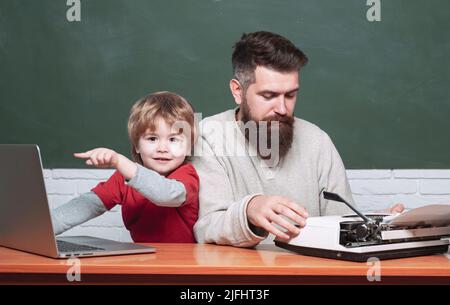 Little students. Teacher and kid. Daddy play with schoolboy. Daddy and his little son. Childhood and parenthood. Young boy doing his school homework w Stock Photo