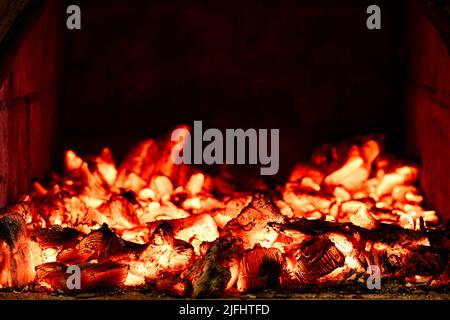 Wood heating in countryside, embers glow in wood burning stove. Stock Photo