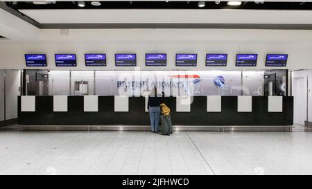 A woman inquires at a near-empty British Airways counter at London Heathrow Terminal 3.  Image shot on 25th June 2022.  © Belinda Jiao   jiao.bilin@gm Stock Photo