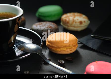 Traditional French assorted desserts, fruit flavour multi colored Macaron on a plate served with coffee, close up shot, full-frame background Stock Photo