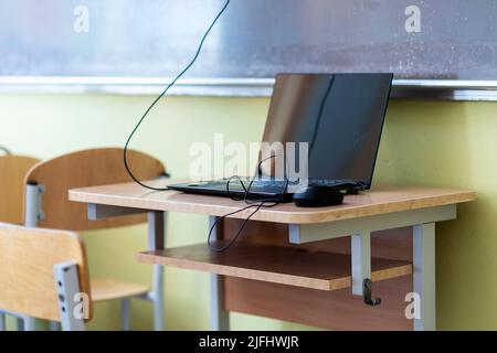 Computer on wooden table in classroom Stock Photo