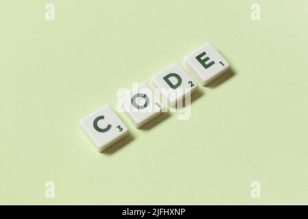 Code formed of scrabble elements on green background. Stock Photo