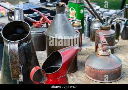 A collection of old, metal oil cans used to apply lubrication to a car engine. Stock Photo