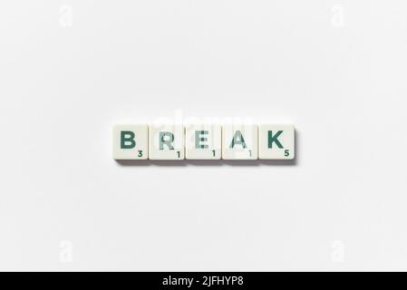 Break formed of scrabble blocks on white background. Stock Photo