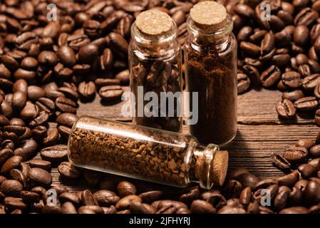 Ground coffee and instant coffee in flasks on a background of roasted coffee Grains Stock Photo