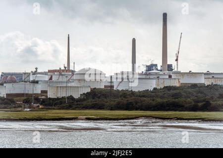 Chimneys and Oil Storage Tankers at ChemicalX Oil Refinery in Fawley, Southampton, England, view from boat. Stock Photo