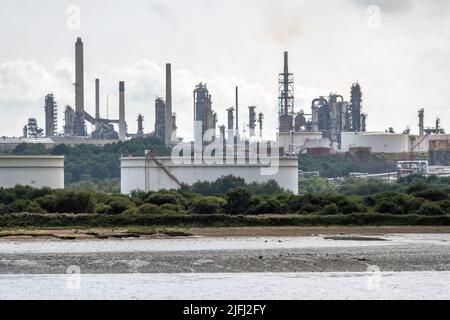 Chimneys and Oil Storage Tankers at ChemicalX Oil Refinery in Fawley, Southampton, England, view from boat. Stock Photo