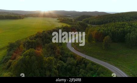 Flight over the serpentine in the mountains on a sunny summer day. Scene. Aerial view of amazing natural landscape. Stock Photo