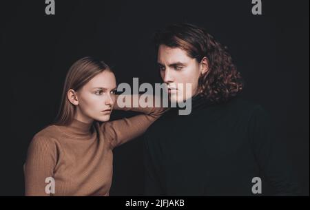 Relationship between male and female. Picture of two friends are standing together over a dark wall. Best friends are ready to overcome everything to Stock Photo