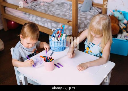 https://l450v.alamy.com/450v/2jfjeyf/two-little-cute-blonde-children-are-drawing-together-at-the-table-2jfjeyf.jpg