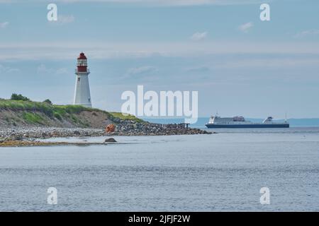 The Low Point Lighthouse is located near New Victoria Nova Scotia and marks the eastern entrance to Sydney Harbour.  Still in operation today it is on Stock Photo