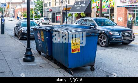 Three metal garbage dumpsters placed on the curb on Murray Avenue in the Squirrel Hill neighborhood in Pittsburgh, Pennsylvania, USA Stock Photo