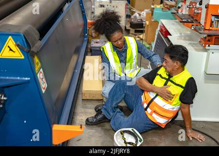 Senior worker accident at machine factory down sick from heart attack friend helping. Stock Photo