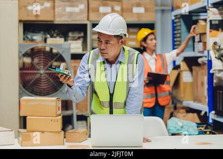 Senior engineer checking product spare part quality and specification received from dealer before collecting in warehouse. Stock Photo