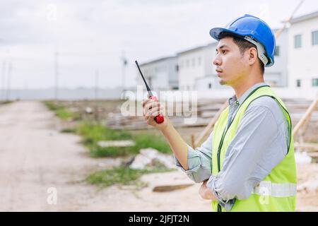 worker foreman engineer builder working using radio command in home construction site safety check. Stock Photo