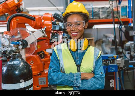Portrait smart woman worker Black African teen girl happy smiling in modern factory Stock Photo