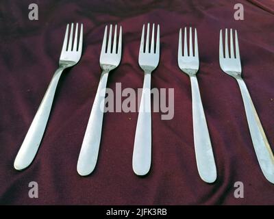 Empty  Steel Fork isolated on violet  background Stock Photo