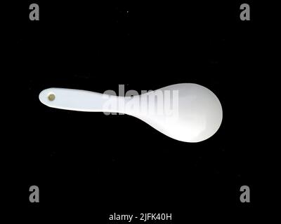 big plastic spoon isolated on black background Stock Photo